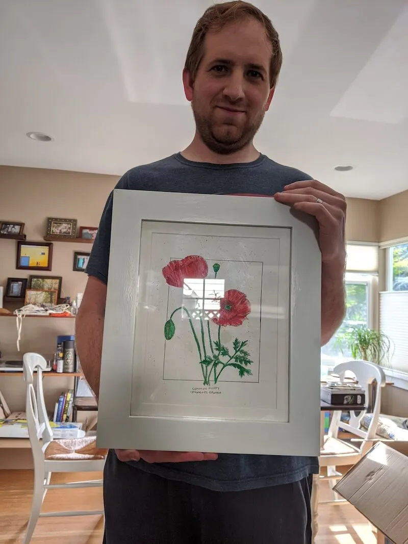 A picture of a flower in a white frame